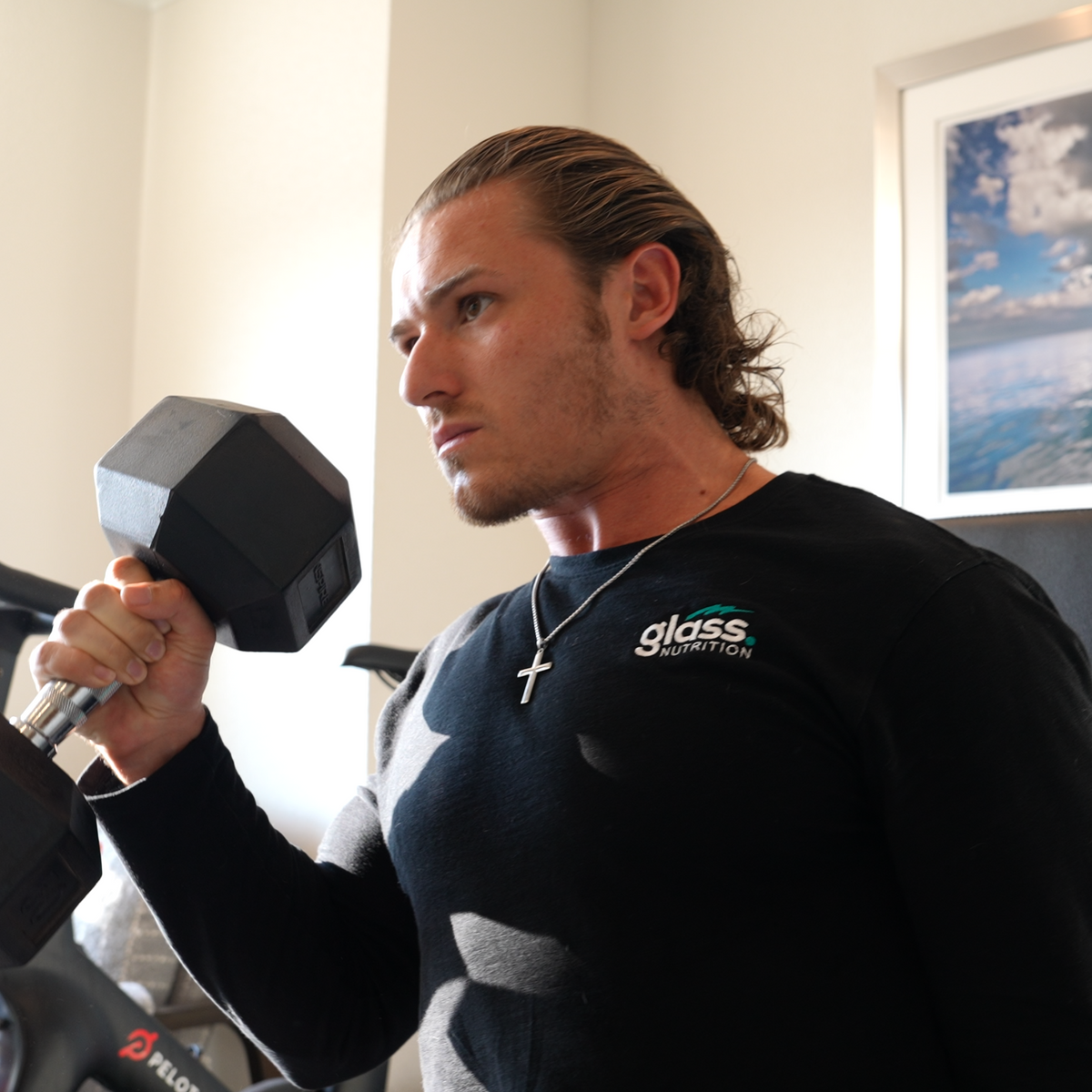The founder of Glass Nutrition curling a dumbbell in a home gym